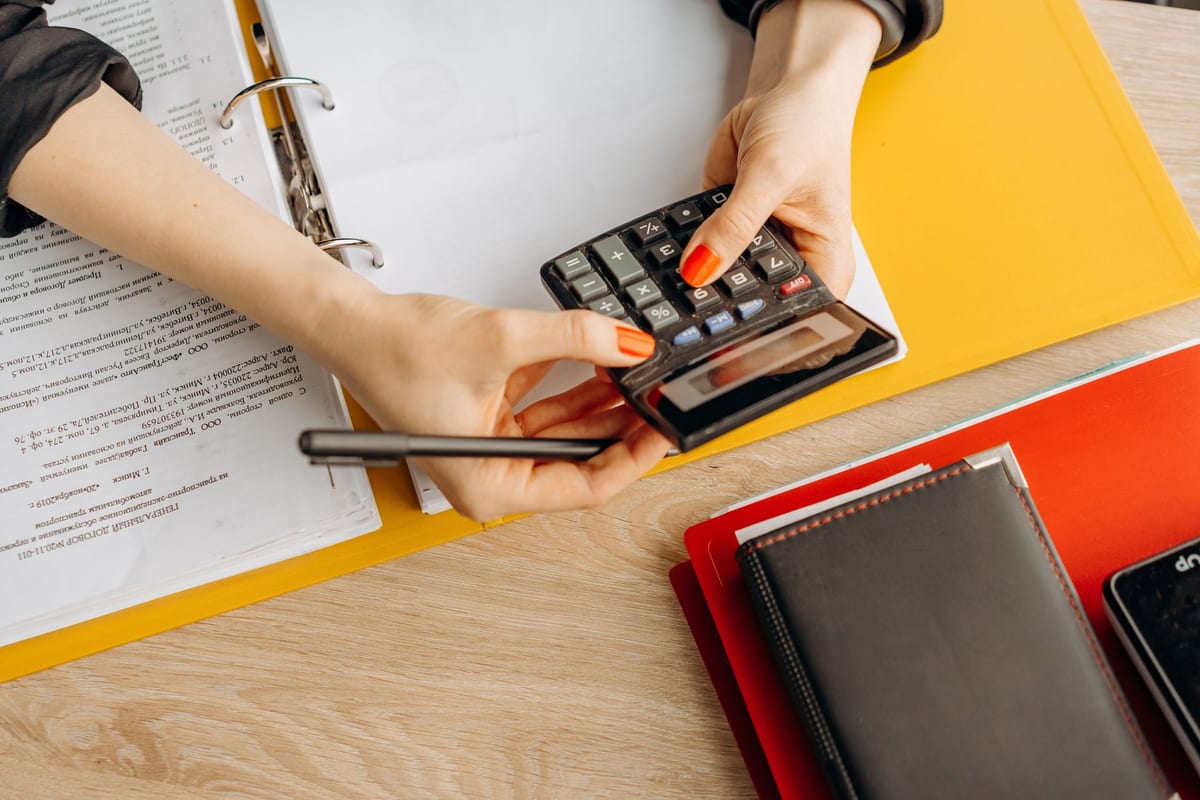 An accountant working through client files at a desk